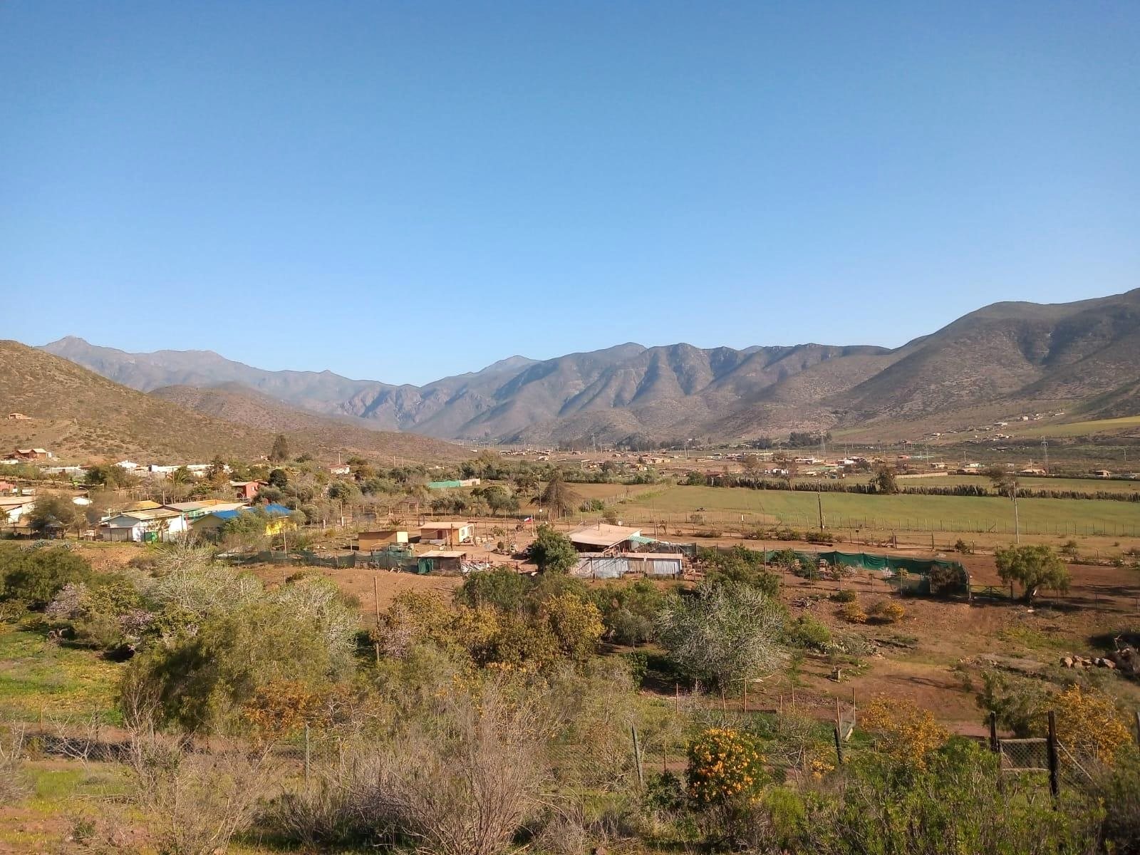 Valle de Cuesta El Manzano con sus praderas, viviendas y el cordón de cerros al fondo
